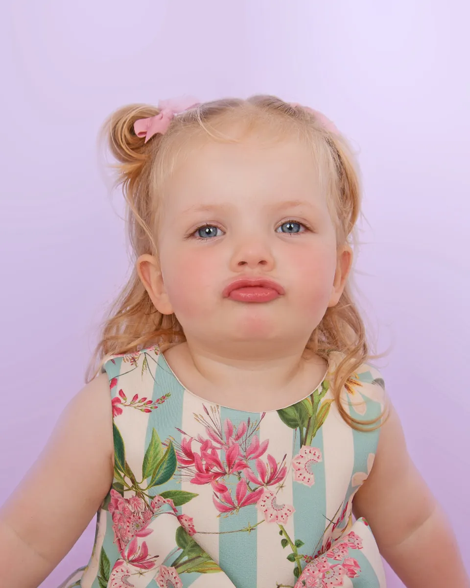 Upright studio portrait of a toddler looking straight into the camera